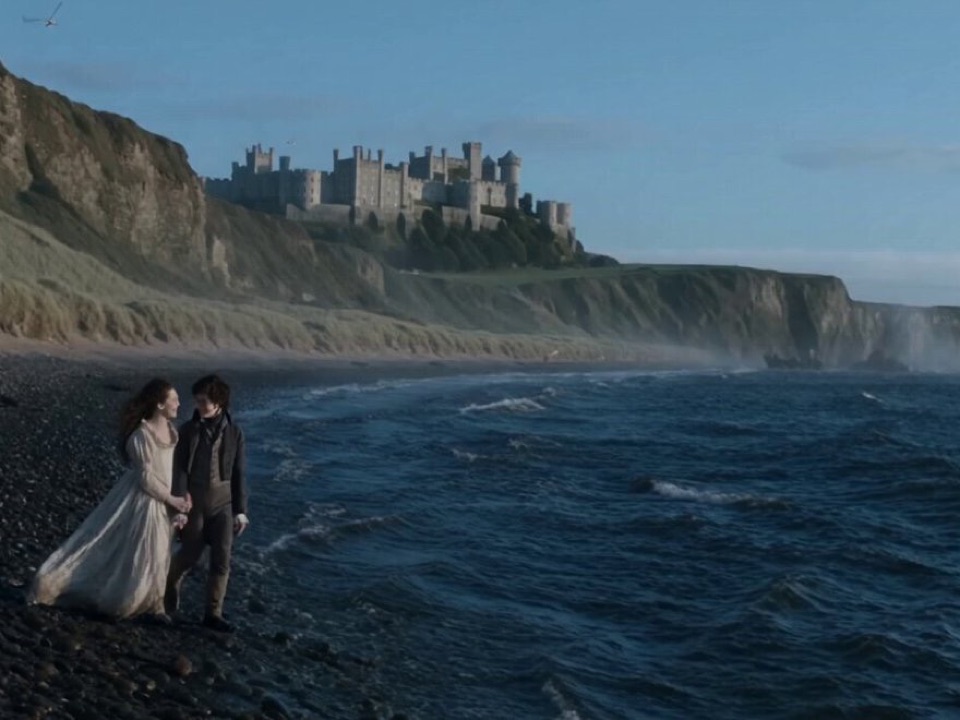 Flux3 cinematic frame of a couple on a coastal beach beneath a castle